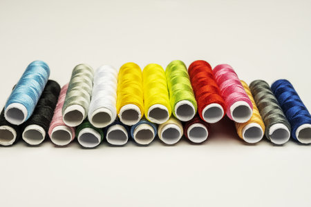 A bunch of spools of different colored sewing thread on a white surfaceの写真素材