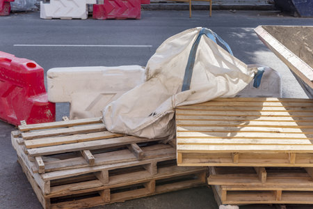 A few pallets of construction materials stacked on the street along with some bags for rubbleの写真素材