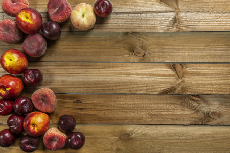 Still life of ripe fruit with plums, nectarines, paraguayans on wooden planksの写真素材