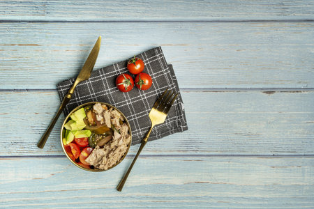 Still life with a tuna salad with tomato, avocado and cherry tomatoes on a gray kitchen towelの写真素材