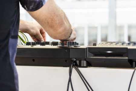 The arms of a dj playing with music on his mixing deskの写真素材