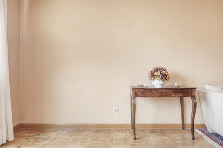 A fancy small antique wooden appliance with a floral centerpiece on the wall in a room with parquet flooringの写真素材