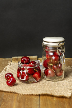 Delicious ripe cherries inside glass jars that ask you to eat themの写真素材