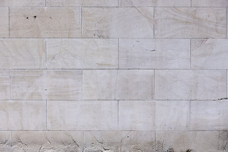 A light colored stone wall with moisture marks at the bottom. Vector stone texture background