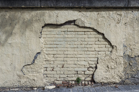 Brick wall covered in cement and paint