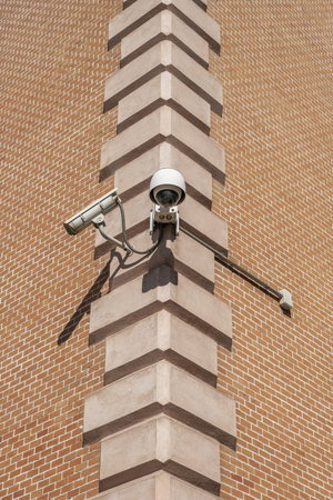 Surveillance cameras hanging from the stone blocks