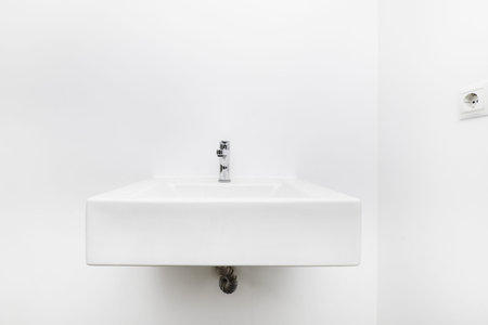 White porcelain sink hanging on the wall in a simple bathroomの写真素材