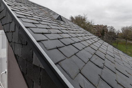 Sloped roofs of a house with black slate tiles