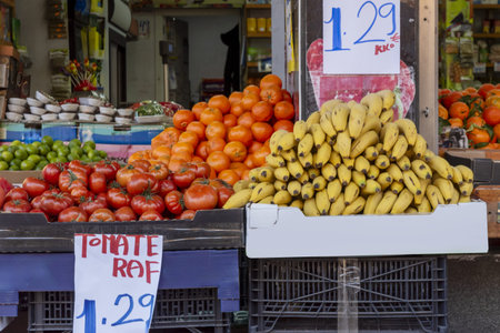 entrance to a fruit shop with bananas, tomatoes and mandarins on offerの写真素材