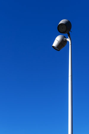 An urban lighting street lamp with two lamps and a deep blue skyの写真素材