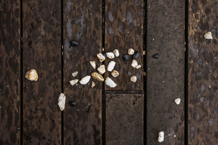 a pile of small stones of various colors on a wooden surfaceの写真素材