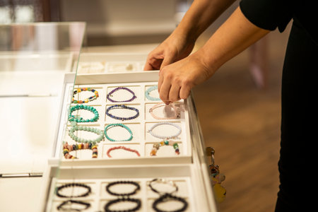 Woman's hands organizing a display of bracelets in a storeの写真素材