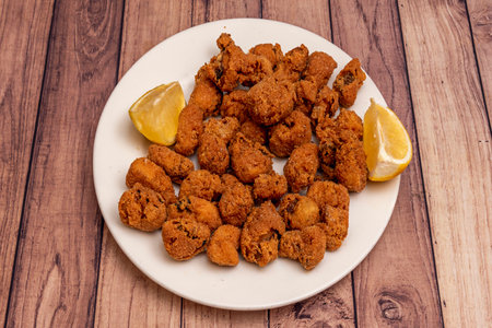 A plate of fried fish with lemon slicesの写真素材