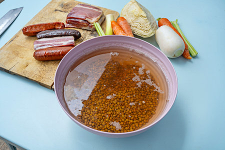 A dish of braised lentils with chorizo and bacon, garnished with freshly chopped parsley for a contrasting colorの写真素材