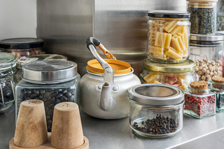 A shelf brimming with glass jars of colorful spices, from the golden hue of turmeric to the deep red of paprikaの写真素材