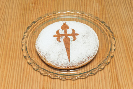 Tarta de Santiago decorated with the stylized Cross of St. James and surrounded by toasted flaked...