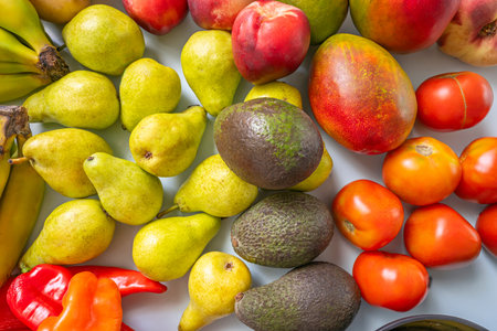 Minimalist still life where bananas, pears, avocados, potatoes, nectarines, and figs create a...