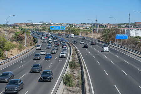 Highway filled with cars and trucks slowly making their way along.