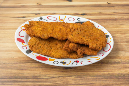 Breaded chicken breast fillets with herbes de Provence, accompanied by a side of creamy mashed...