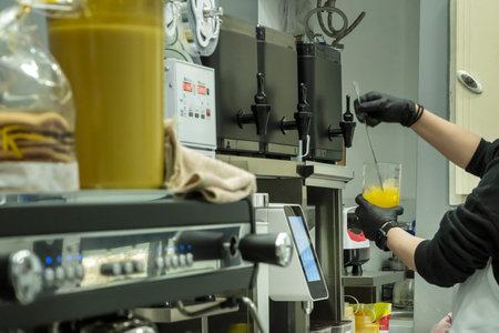 A waitress preparing a drink made with fruit and ice