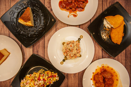 Tradition elevated to art in its presentation: black rice with a crispy socarrat and aioli, accompanied by grilled cuttlefish and a skewer of prawns and bell peppersの写真素材