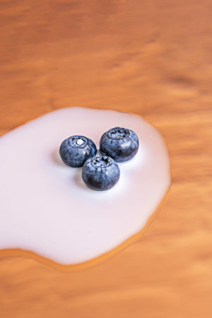 Image of a white ceramic bowl filled to the brim with blueberries, placed on a smooth, light-colored...