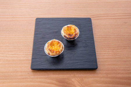 A close-up revealing the interior of a Pastel de Nata as it is cut in half, showing how the delicate...