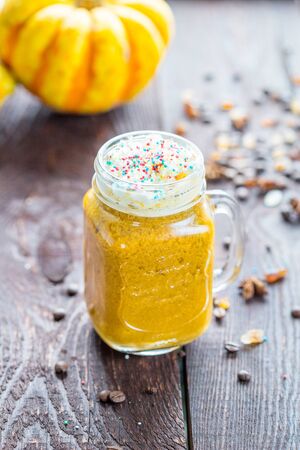 Pumpkin Spiced Latte in a Jar on a Dark Brown Vintage Tableの写真素材