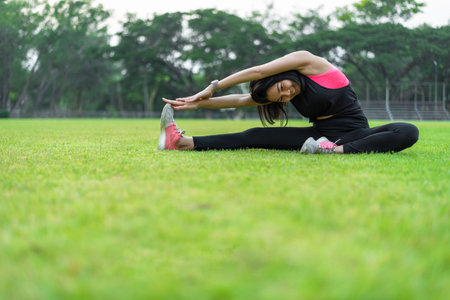 Women warm up before exercising outdoors during the morning hours in the park.