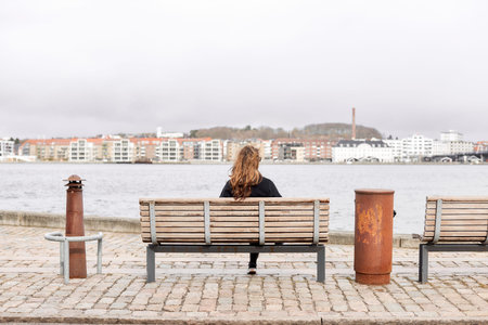 A person sitting on a bench next to a body of water
