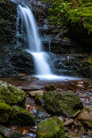 Waterfall in a forest with flowing waterの写真素材