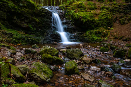 Waterfall in a forest with flowing waterの写真素材