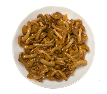 Marinaded mushrooms in spoon, isolated on white.の写真素材