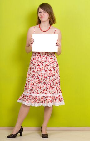 Lady holding a blank paper. On green background.の写真素材