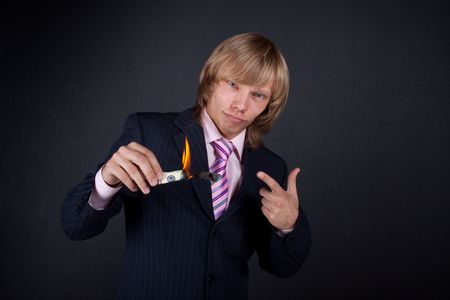 Man burns out dollars on black background.の写真素材