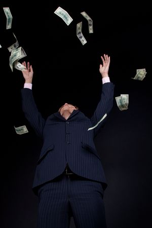 Buisnessman and falling down money. On black background.の写真素材