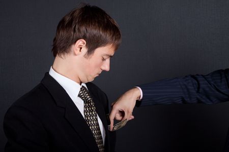 Chief pay out a salary. On black background.の写真素材