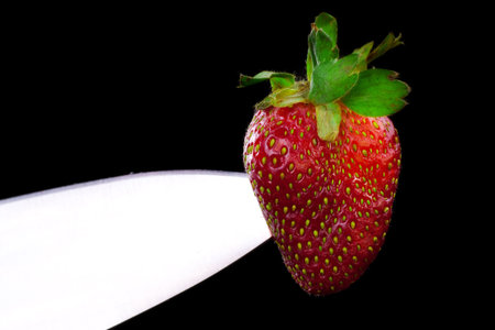 Cut strawberries. Isolated on black.の写真素材