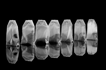 The tea bags isolated on black.の写真素材