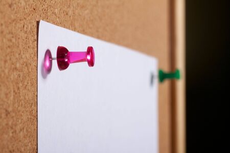 Paper with push pins on cork board. Crop.の写真素材