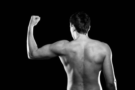 Portrait of handsome muscleman against dark backgroundの写真素材