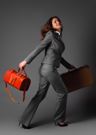 A businesswoman with a bag and a suitcase.の写真素材