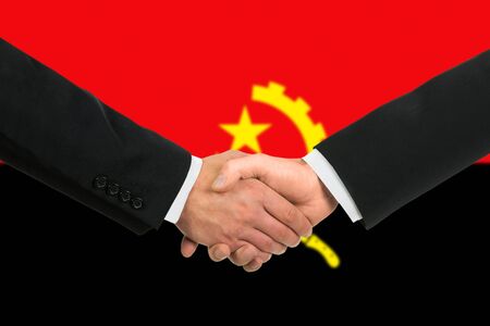 The Angolan flag and business handshakeの写真素材