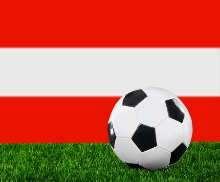 The Austrian flag and soccer ball on the green grass.の写真素材
