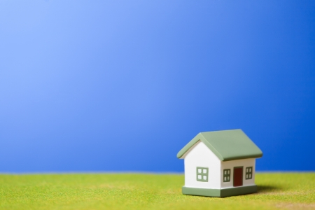 Toy model house on green grass  Conceptual imageの写真素材