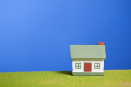 Toy model house on green grass  Conceptual imageの写真素材