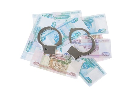 financial crime. Steel handcuffs and money, isolated on whiteの写真素材