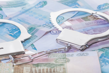 financial crime. Steel handcuffs and money, closeupの写真素材