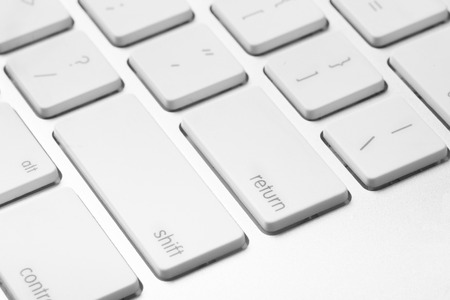 Close-up of white keyboard with enter key in focusの写真素材