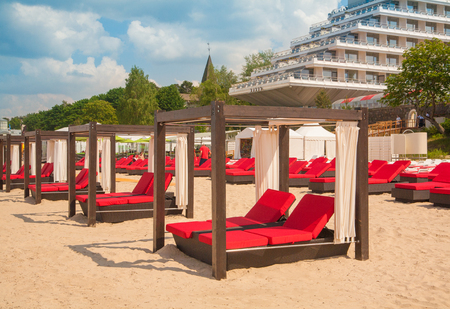 Empty sunbeds in a row on the sand beach and hostelの写真素材